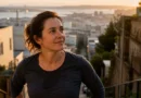 Woman pauses after climbing outdoor stairs at sunrise, showing the health benefits of exercise beyond weight loss through energy, clarity, and confidence
