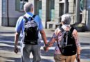elderly couple holding hands and walking.