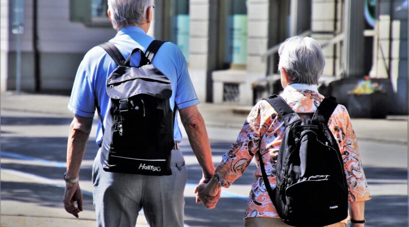 elderly couple holding hands and walking.